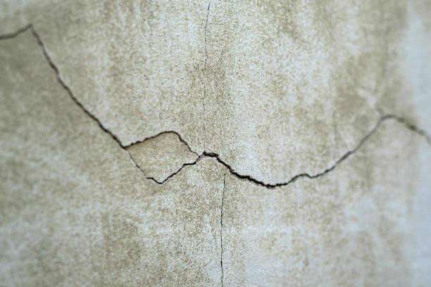 istock Old foundation and plaster wall with cracks. Building requiring repair closeup. 1160767662