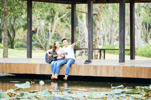 istock Couple playing guitar outdoors 1160767698