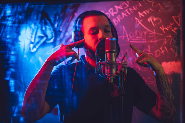 Rap musician in studio Young caucasian male rap musician singing in studio in deaf room. attraction studio photography stock pictures, royalty-free photos & images