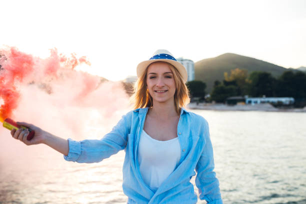 istock Woman having fun with smoke bomb on the beach 1160771702