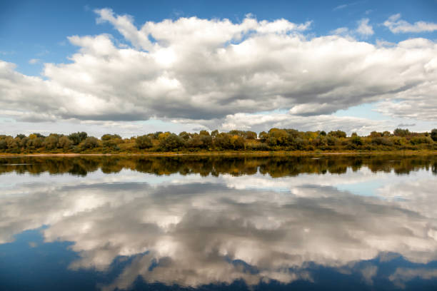 istock A beautiful autumn landscape, a forest reflected in a river, the sky with clouds. 1160772243