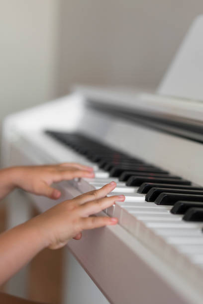 istock Little girl's small hands playing a piano 1160773377