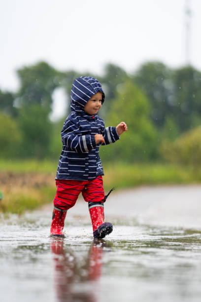 istock nearly 2 years old girl having fun outdoors in rain 1160774747