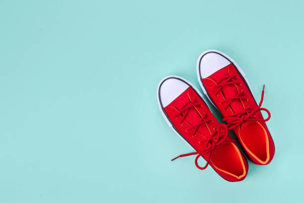istock New red sneakers on green background with copy space. 1160774778