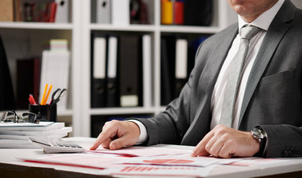 istock Businessman working and calculating, reads and writes reports. Office employee, table closeup. Business financial accounting concept. 1160778642