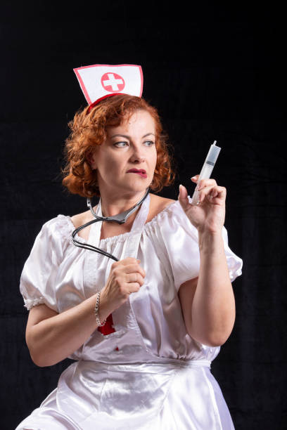 A woman nurse in uniform holds a syringe and stethoscope.