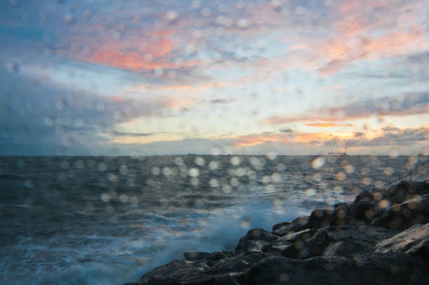 drammatica onda oceanica schizzo la sera con cielo crepuscolare in inverno al breakwater al molo di st kilda a melbourne in australia - melb foto e immagini stock