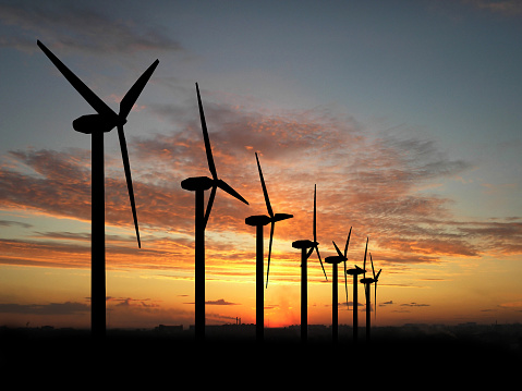 Wind turbine farm over sunset