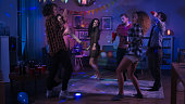 At the College House Party: Diverse Group of Friends Have Fun, Dancing and Socializing. Boys and Girls Dance in the Circle. Disco Neon Strobe Lights Illuminating Room.