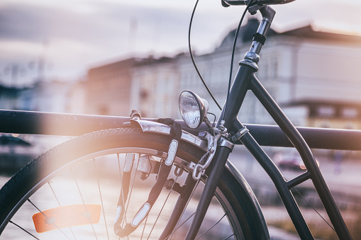Detail of a black retro bicycle on a city background, image with vintage toning