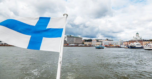 A Finnish flag on a boat, develops in the wind with a view of the sea. Travel to Finland, Scandinavian Europe