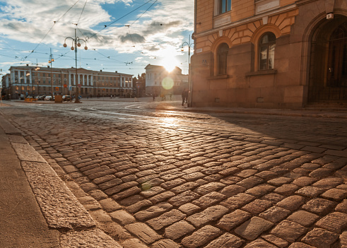 Beautiful cityscape, Helsinki, street in the historical center of the city with paving stones in the rays of the setting sun