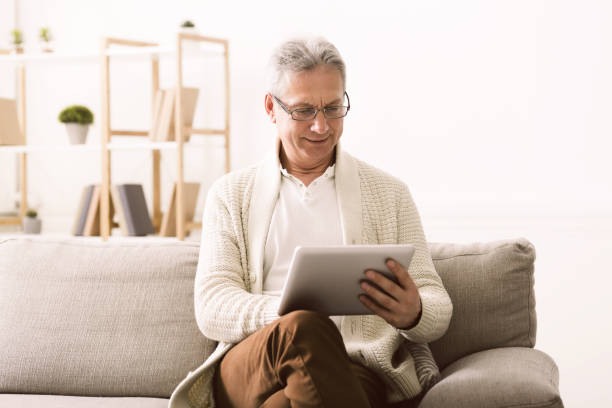 istock Senior man surfing net on digital tablet at home 1160785273