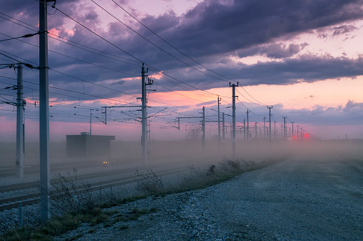 Railway at sunset with dust and thunderstorm