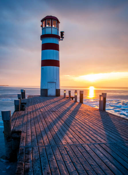istock Winter landscape with lighthouse on a lake at sunset 1160786945