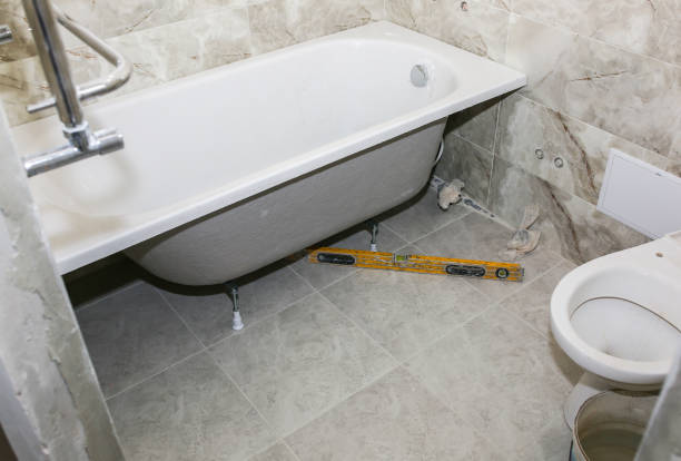 istock Bath installation. Measures with spirit level. Maintenance repair in the flat. Renovation process. 1160788483