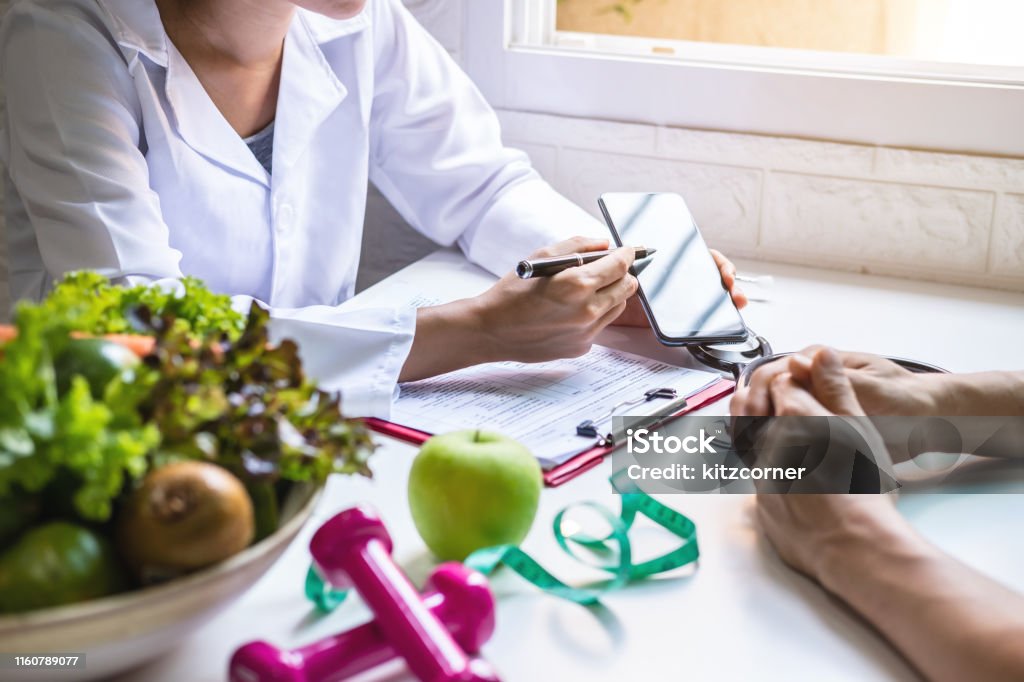 Nutritionist giving consultation to patient with healthy fruit and vegetable, Right nutrition and diet concept Healthy Eating Stock Photo