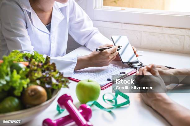 Nutritionist Giving Consultation To Patient With Healthy Fruit And Vegetable Right Nutrition And Diet Concept Stock Photo - Download Image Now