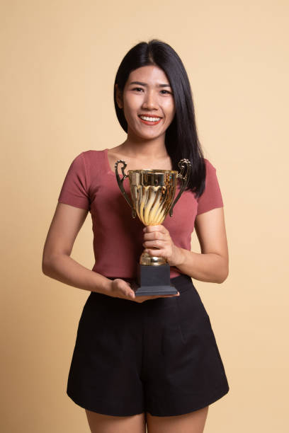 istock Successful young asian woman holding a trophy. 1160790425