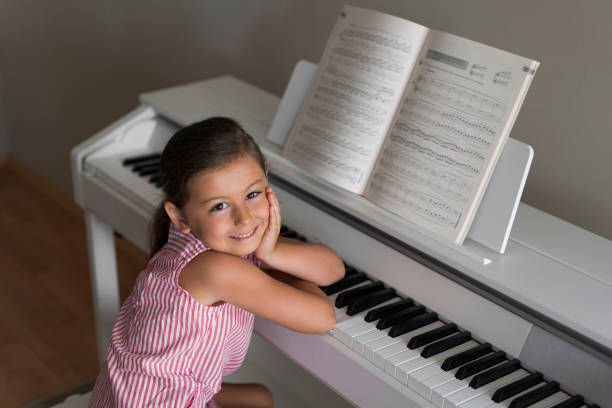 Cute little girl playing piano at home Cute little girl playing piano at home girl playing piano stock pictures, royalty-free photos & images