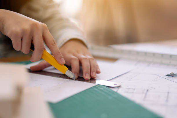 istock An architect working and cutting papers in office 1160791778