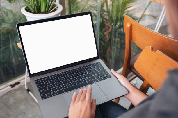 istock Mockup image of a woman using and touching laptop touchpad with blank white desktop screen while sitting in cafe 1160791848