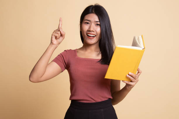 istock Young Asian woman with a book have an idea. 1160792552