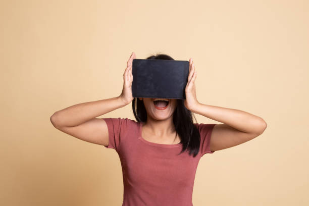 istock Young Asian woman with a computer tablet over her face. 1160793301