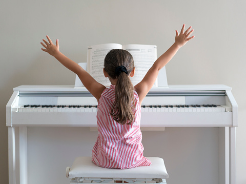 Cute little girl playing piano at home