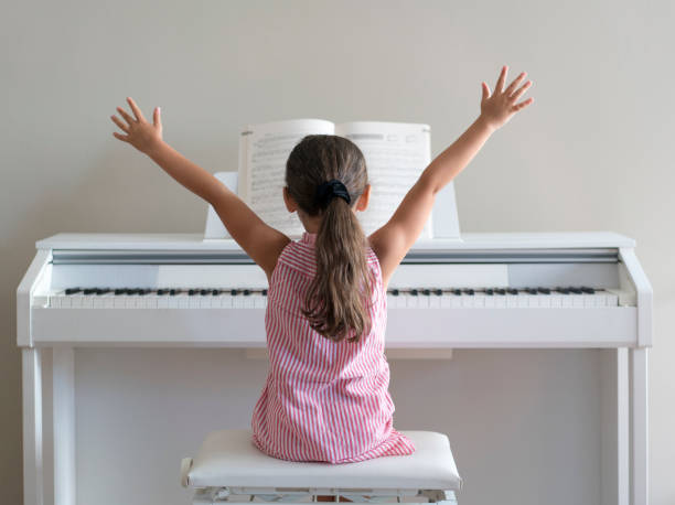 cute little girl playing piano at home - practicing piano child playing imagens e fotografias de stock