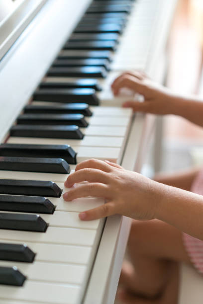 istock Little girl's small hands playing a piano 1160794107