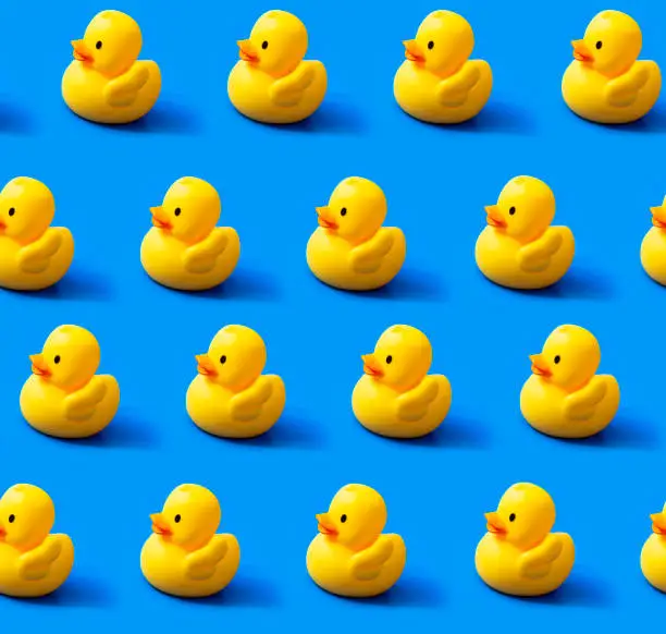 Seamless endless repeating pattern. Rubber yellow ducks on a blue background