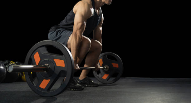 beau haltérophile se préparant pour la formation. entraînement avec barbell, jeune sportif torse nu athlétique. modèle de forme physique avec le barbell dans la gymnastique - muscular build wellbeing exercise equipment instructor photos et images de collection