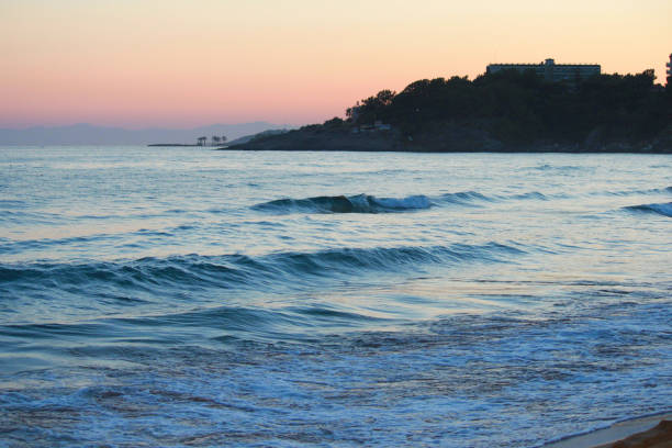 istock Landscape of tropical beach sunset. Waves, mountains, palm trees. 1160795720