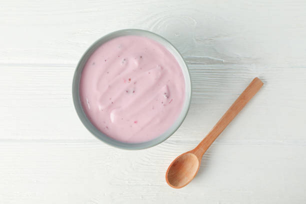 istock Fruit yogurt in bowl and spoon on white wooden background 1160796328