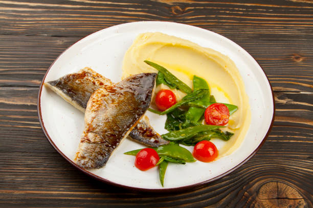 istock baked fish with vegetables on wooden background 1160797129