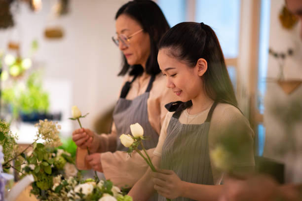 istock Women arranging roses in floral training class 1160798559