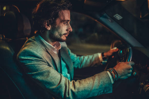 istock Businessman Driving A Car In Night 1160802879