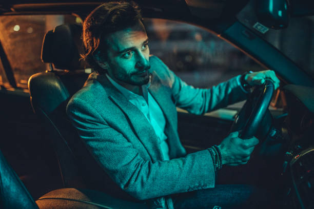 istock Businessman Driving A Car In Night 1160804241