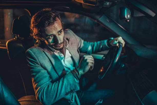 istock Businessman Driving A Car In Night 1160804329