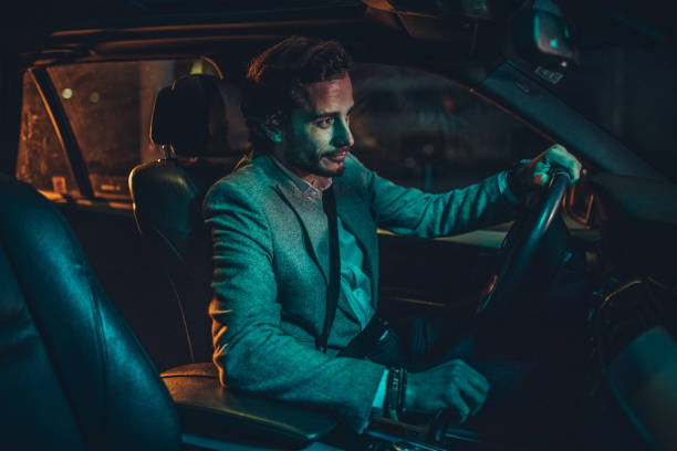 istock Businessman Driving A Car In Night 1160804570