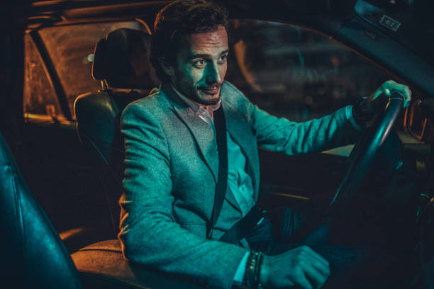 istock Businessman Driving A Car In Night 1160804624