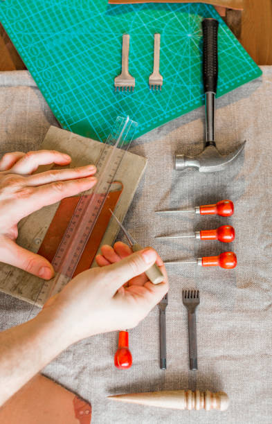 istock Close up hands of a leather craftsman working with leather textile at a workshop 1160805608