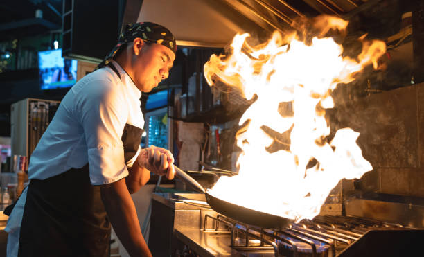 istock Chef working at a restaurant flambing food 1160806010