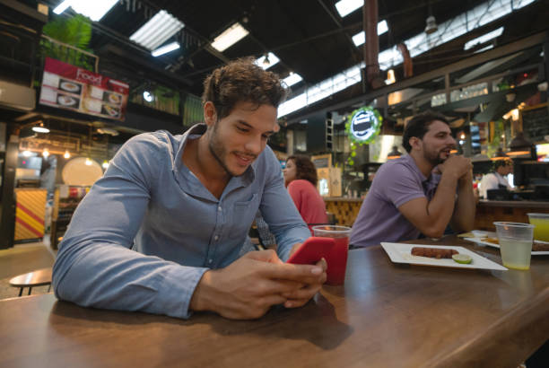 istock Man eating at a restaurant and texting on his cell phone 1160806067