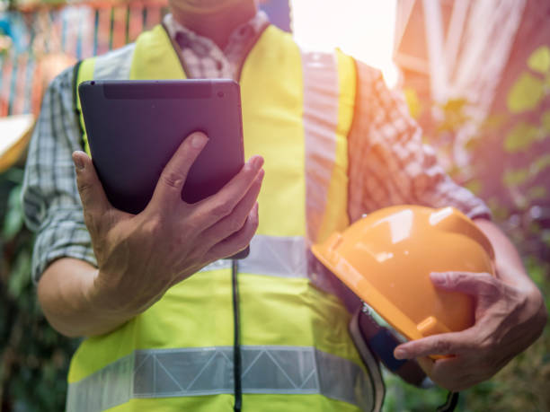 istock Engineering man standing with yellow safety helmet and holding tablet, work concept 1160810649