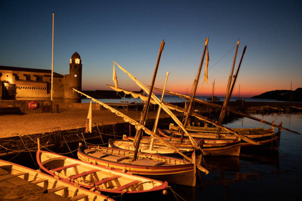 Catalan boat at dawn - Collioure Some Catalan boats are moored in the port of Collouire, peacefully waiting for sunrise, under the eye of the bell tower. collioure stock pictures, royalty-free photos & images
