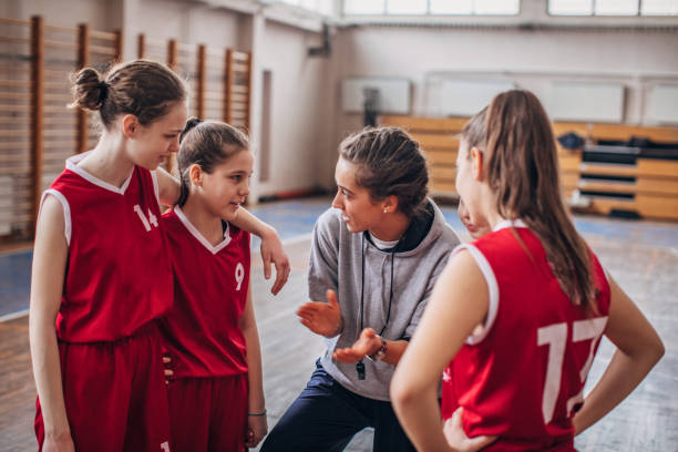istock Coach standing with basketball team 1160812023