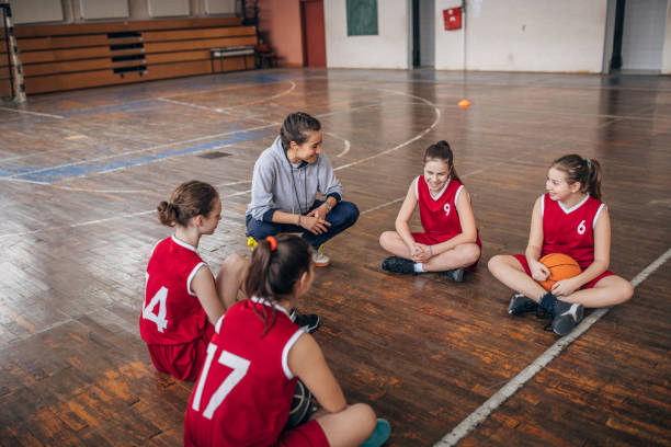 istock Coach standing with basketball team 1160812396