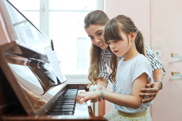istock Woman piano teacher educating child 1160812404